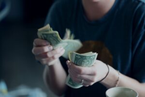 Woman counting her personal debt accumulated from credit card debt, and car loan debt